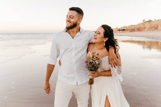 Married couple in wedding outfits on the beach